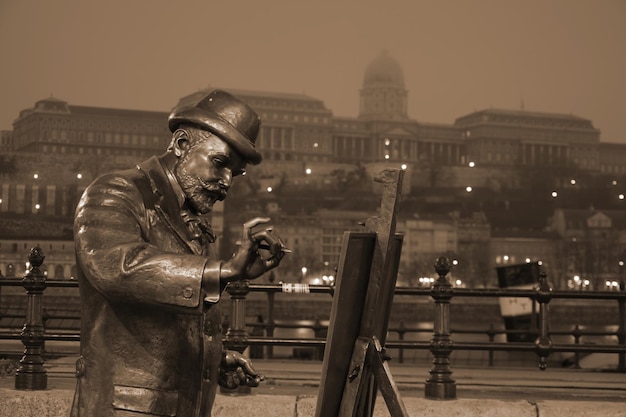 Photo close-up d'une sculpture de peintre contre un bâtiment historique la nuit