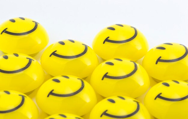 Close-up d'un smiley anthropomorphique sur des boutons sur un fond blanc