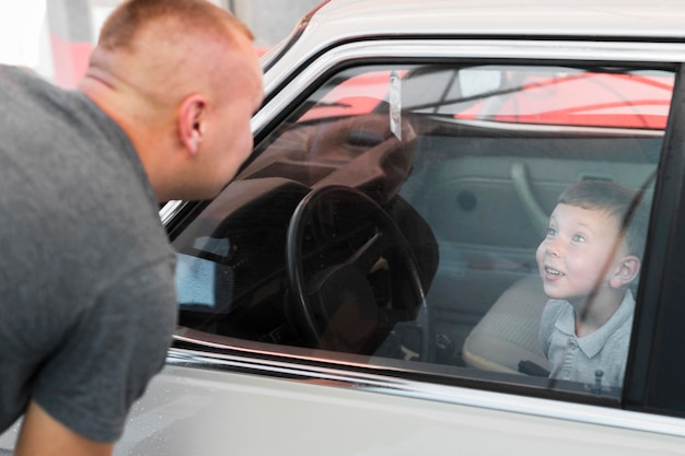 Close-up smiley kid assis dans la voiture