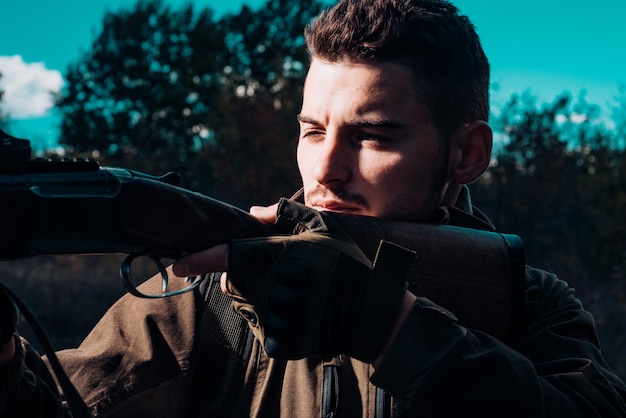 Photo close up snipers carabine à la chasse en plein air close up portrait of hamdsome hunter hunter avec sho