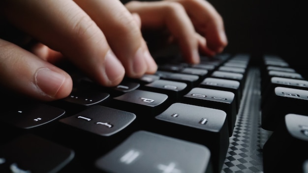 Close-up soft-focus doigt tapant sur le clavier. Main de l'homme à l'aide d'un ordinateur portable au bureau. Concept d'entreprise de programmation et de marketing en ligne.