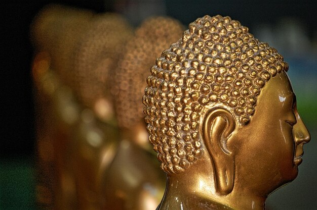 Photo close-up des statues d'or de bouddha en rangée au temple