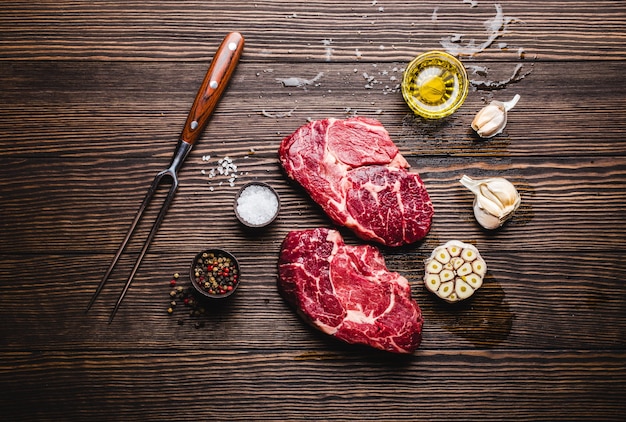 Close-up de steak de viande marbrée crue Ribeye sur fond de bois rustique