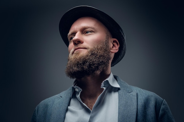 Close up studio portrait of male barbu dans un chapeau de feutre sur fond gris.