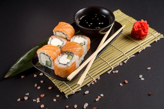 Close up sushi rolls dans une plaque noire sur fond sombre