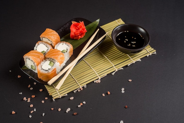 Close up sushi rolls dans une plaque noire sur fond sombre