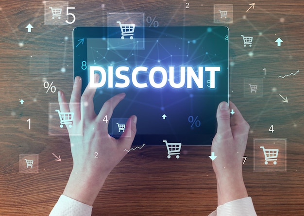 Close-up d'une tablette à main avec l'inscription DISCOUNT concept d'achat en ligne.