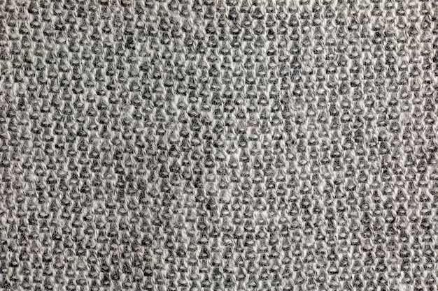 Close-up de tapis à tricot gris Texture textile sur un fond gris Arrière-plan détaillé à partir de fil chaud Fragment de pull en tissu de laine naturelle