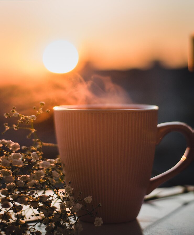Photo close-up d'une tasse de café contre le ciel au coucher du soleil