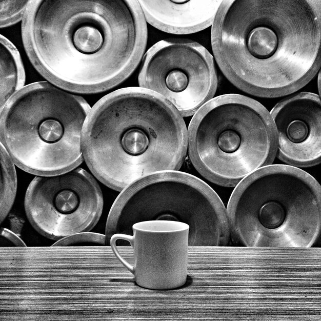 Photo close-up d'une tasse de café sur la table contre le mur avec une décoration métallique