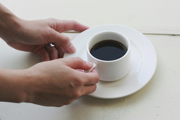 Close-up d'une tasse de café tenue à la main