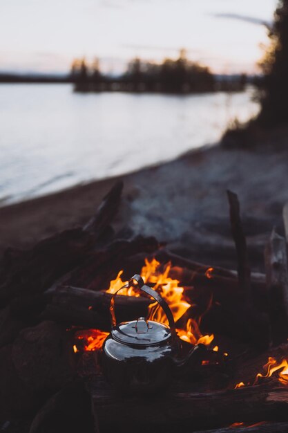 Photo close-up d'une théière sur un feu de camp