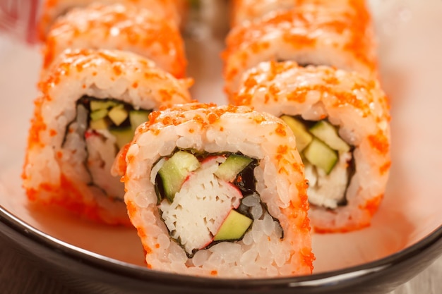 Close up Uramaki California Sushi rolls avec des morceaux de riz nori de bâtonnets de crabe concombre avocat