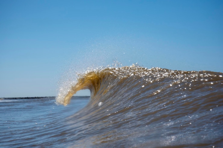 Photo close-up des vagues de la mer éclaboussant contre un ciel dégagé