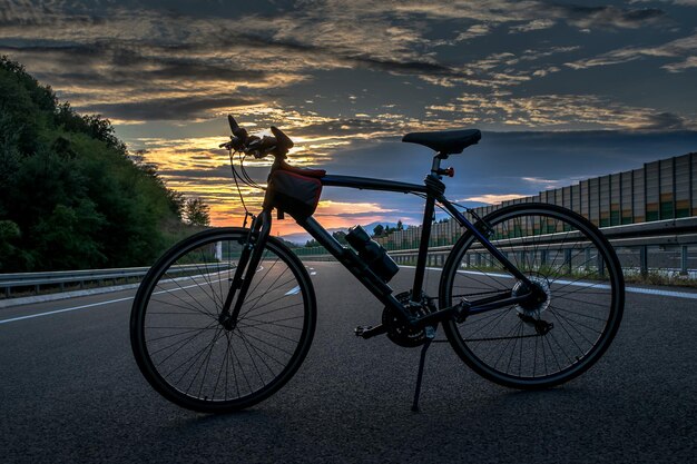 Photo close-up d'un vélo garé sur la route contre le ciel au coucher du soleil