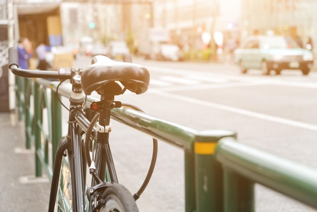 Photo close-up d'un vélo garé sur un trottoir par une rue de la ville pendant une journée ensoleillée