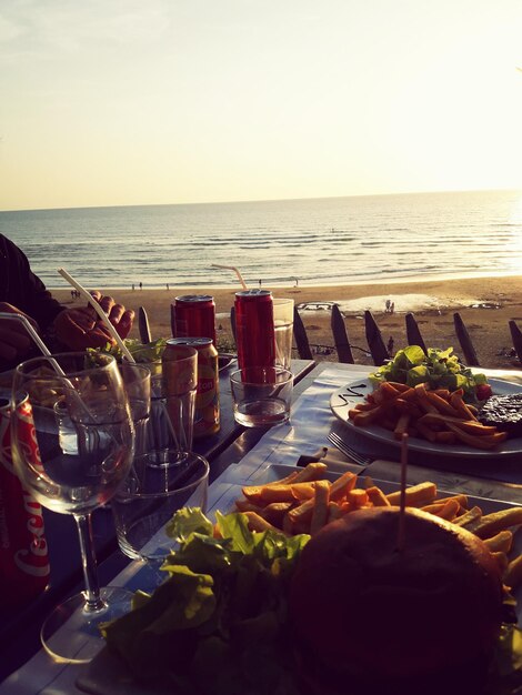 Photo close-up de verres à vin sur la table à la plage contre un ciel dégagé