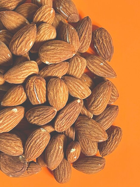 Close up vertical de tas d'amandes sur fond orange