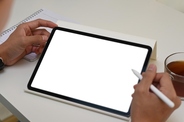 Close up vie of man holding digital tablet avec écran vide et stylet