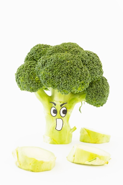 Close-up d'un visage anthropomorphe sur du brocoli sur un fond blanc