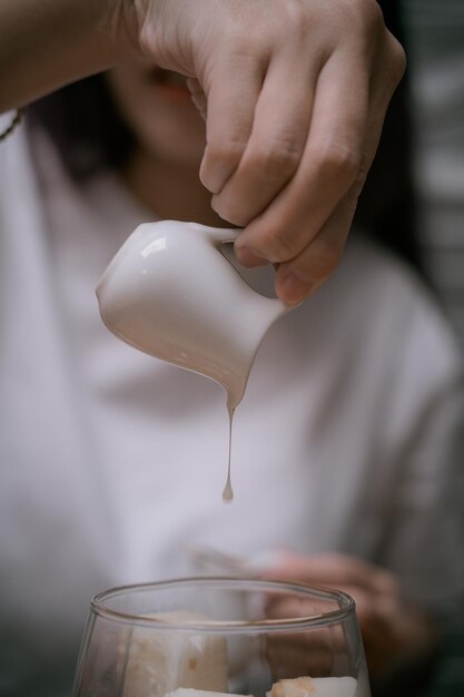 Close up Woman Hands verse du lait dans le thé au citron froid ou le café pour le menu Cold Brew