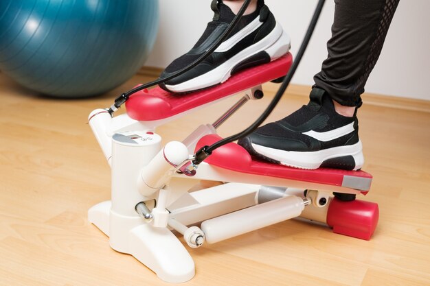 Close up womans pieds dans les baskets de formation sur le stepper twist