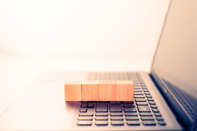 Close up wood block stacking on laptop Business concept Copy space