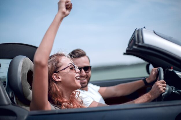 Close upa jeune femme avec son petit ami dans une voiture décapotable