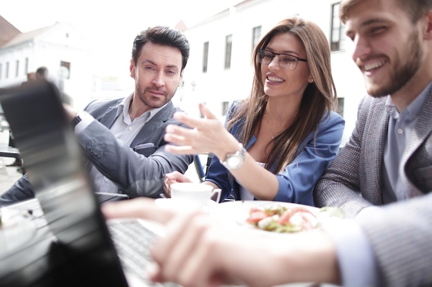 Close upbusiness team assis à une table dans un café de la rue le concept de travail d'équipe