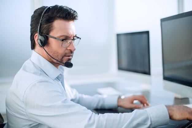 Close upbusinessman avec un casque travaille dans un bureau moderne et de la technologie