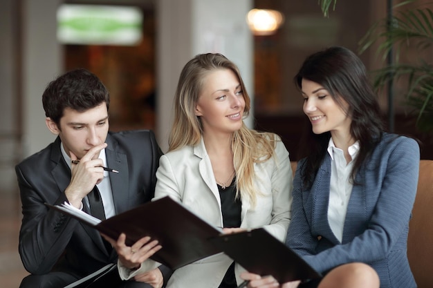 Close upcolleagues discutant du document financier dans le hall de la Banque