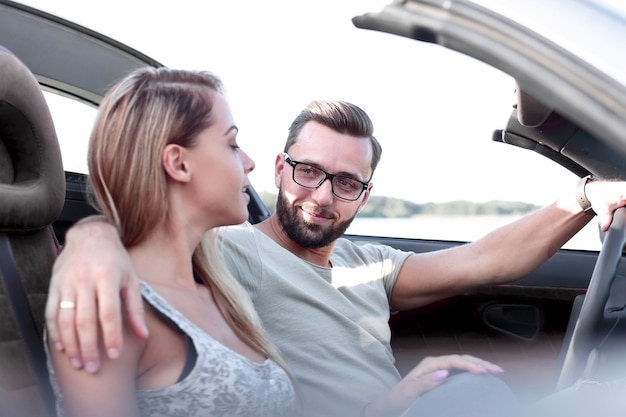 Close upjeunes mariés voyageant dans une voiture décapotable