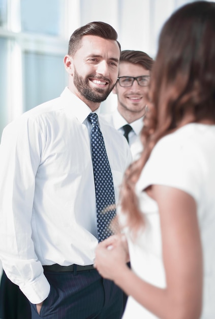 Close upManager parlant aux employés debout dans les gens d'affaires de bureau