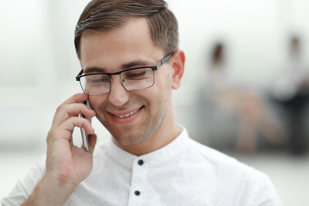 Close upsmiling businessman parler sur son smartphone