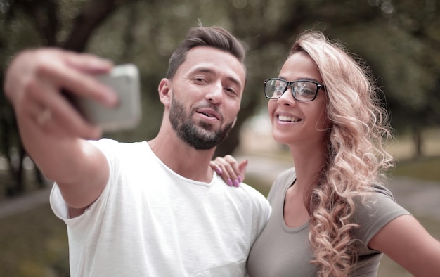 Close upsmiling jeune couple prenant selfie dans le parc de la ville