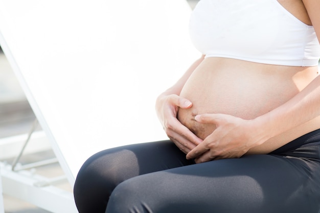 Closeup belle femme asiatique enceinte se détendre dans le parc.