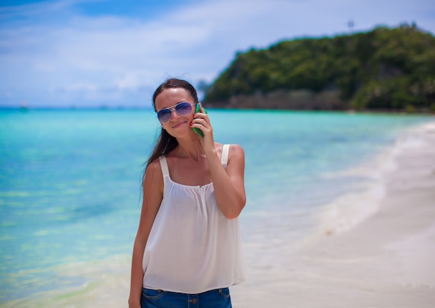 Closeup belle jeune femme à la plage parler sur son téléphone