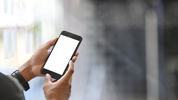 Closeup businessman holding smartphone au bureau.