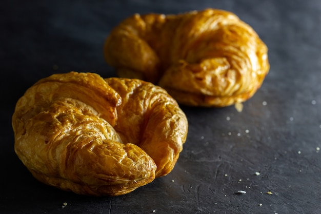 Closeup croissant sur la table en fond sombre.