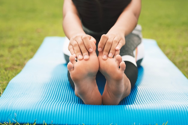 Closeup foots d&#39;une jeune femme pratiquant l&#39;yoga au parc