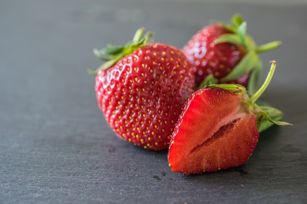 Closeup macro fraises délicieuses fraîches sur ardoise foncé