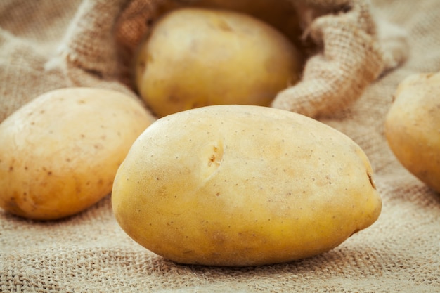 Closeup pommes de terre biologiques fraîches sur fond de sac de chanvre.