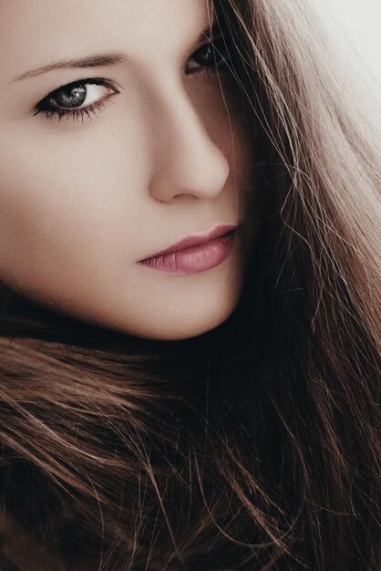 Closeup portrait de beauté d'une femme avec un maquillage chic et une peau parfaite fille brune avec de longs