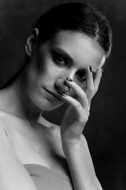 Closeup portrait d'une belle femme brune qui pose au studio. Prise de vue monochrome