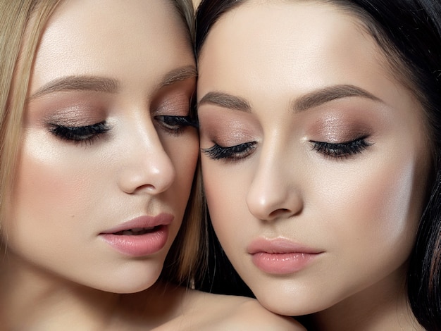 Closeup portrait de deux belles jeunes femmes. Couleurs beiges crémeuses. Maquillage nu. Soins de la peau, cosmétiques, thérapie SPA ou concept de cosmétologie