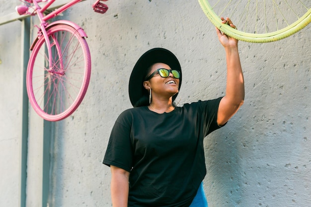 Closeup portrait élégante jeune fille afro-américaine aux cheveux bouclés dans des lunettes de soleil à la mode en milieu urbain avec espace de copie et lieu pour la publicité de photos hipster d'été avec style instagram