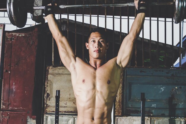 Closeup portrait d&#39;un entraînement musculaire homme avec haltères au gymnase local