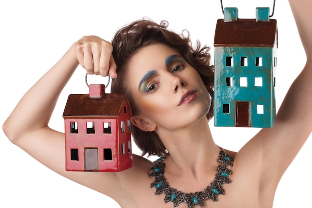 Closeup portrait fille architecte avec maquillage couleur tenant une maison modèle sur fond blancxA