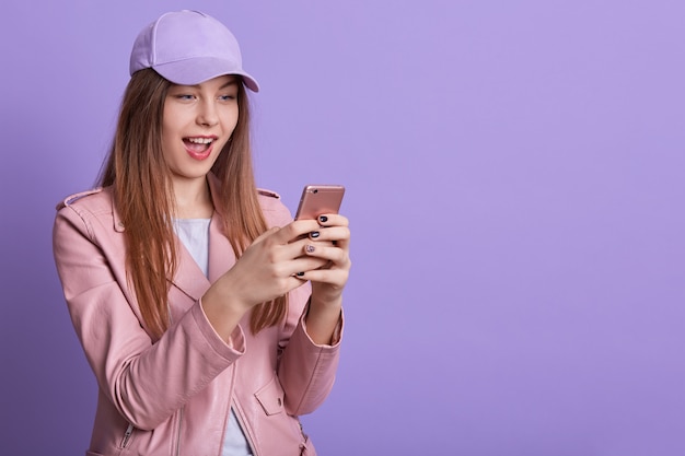 Closeup Portrait De Fille Heureuse Avec La Bouche Ouverte, En Gardant Le Téléphone Intelligent Moderne Dans Les Mains