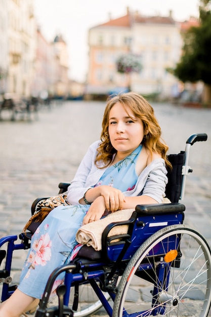 Closeup portrait de jeune femme handicapée souriante en fauteuil roulant